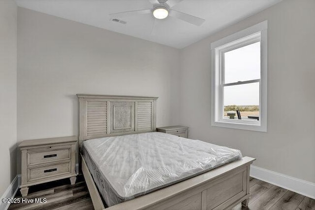 bedroom with visible vents, baseboards, ceiling fan, and dark wood-style flooring