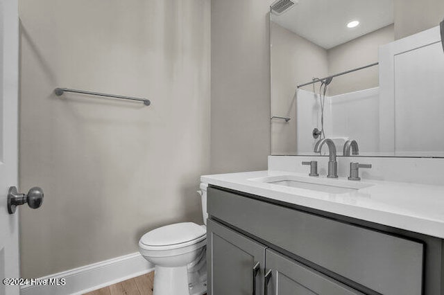 bathroom with vanity, toilet, wood-type flooring, and walk in shower