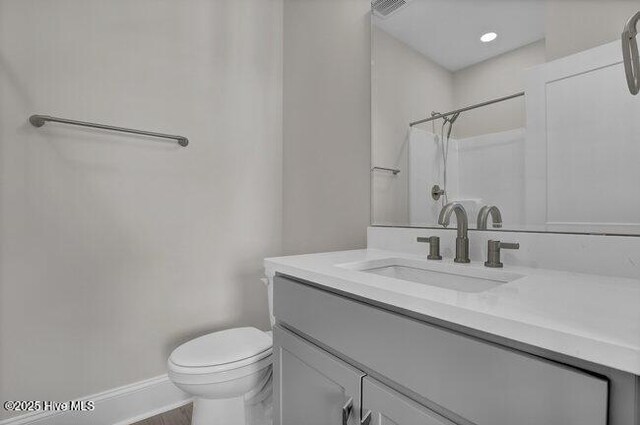 bathroom featuring hardwood / wood-style floors, vanity, toilet, and walk in shower