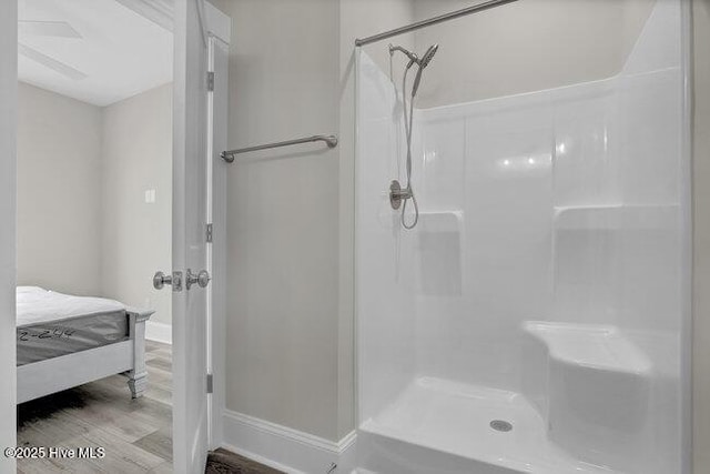 full bathroom with baseboards, walk in shower, and wood finished floors