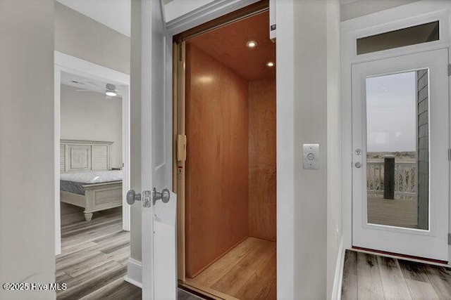 bathroom with elevator and wood finished floors