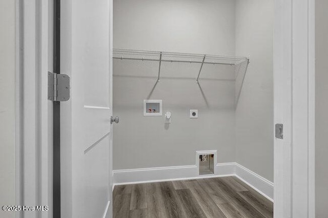 laundry area with baseboards, dark wood finished floors, laundry area, electric dryer hookup, and washer hookup