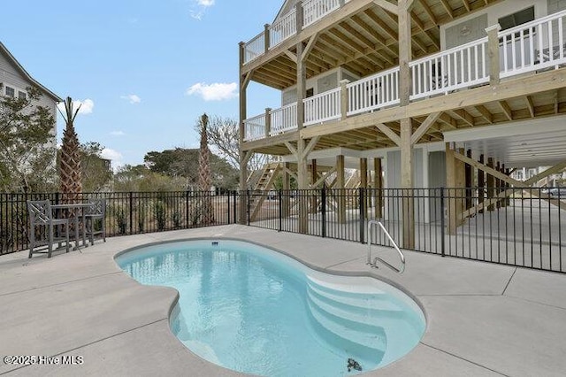 view of swimming pool featuring a patio area, stairway, a fenced in pool, and fence