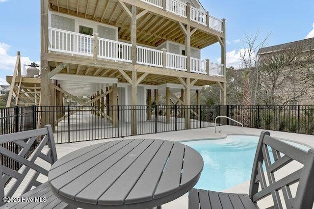 wooden terrace featuring a fenced in pool and fence