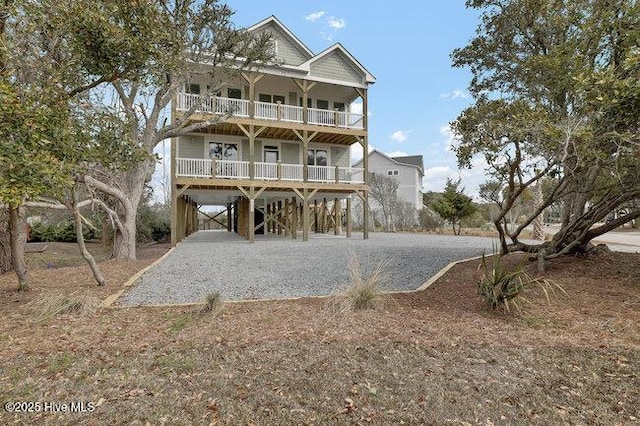 view of front facade with a carport, gravel driveway, and a balcony