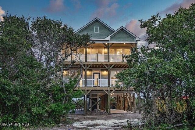 back house at dusk with a balcony