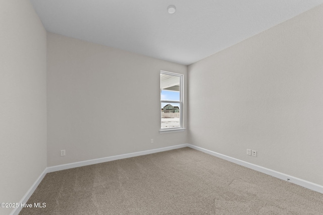 carpeted spare room with baseboards