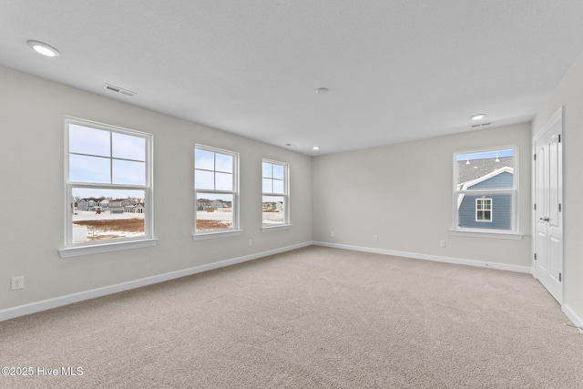 spare room with visible vents, recessed lighting, baseboards, and light colored carpet