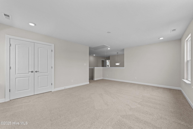 unfurnished living room featuring carpet, attic access, recessed lighting, baseboards, and visible vents