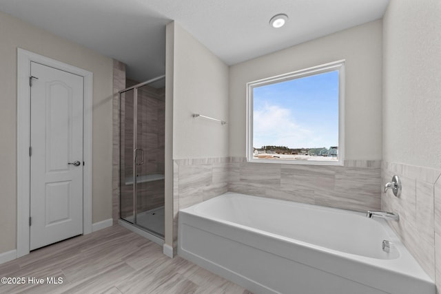 full bath with a garden tub and a stall shower