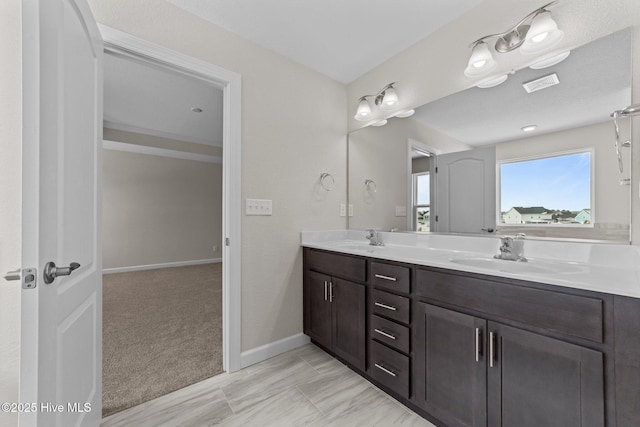 bathroom featuring double vanity, baseboards, visible vents, and a sink
