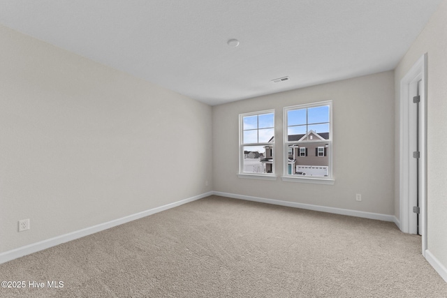 carpeted empty room with baseboards and visible vents