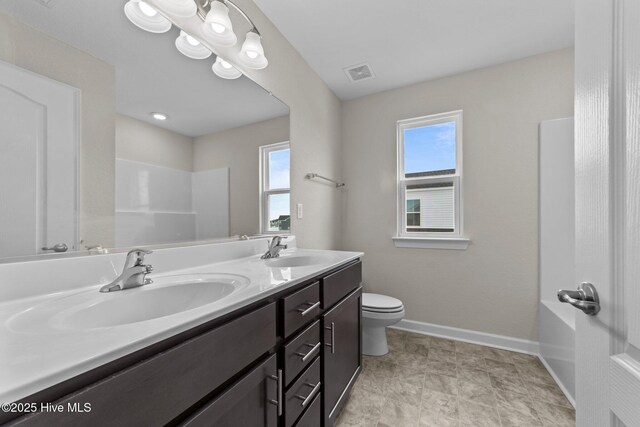 full bathroom featuring double vanity, baseboards, visible vents, and a sink