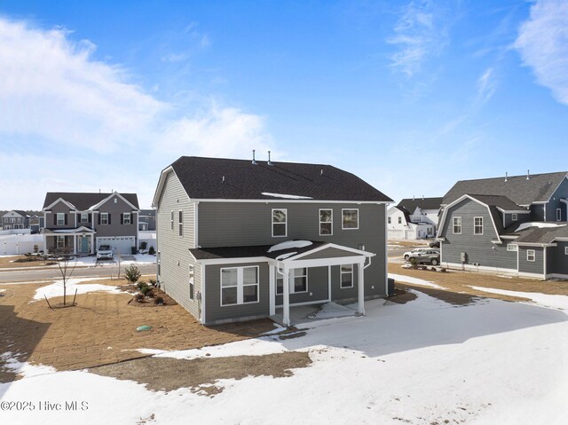 snow covered house with a residential view