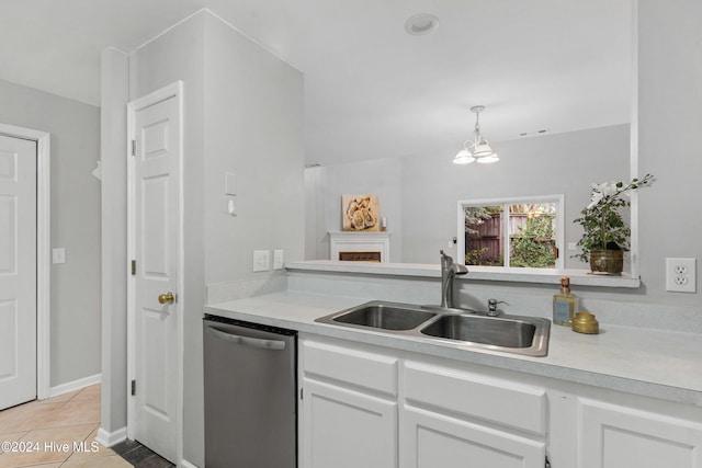 kitchen featuring light tile patterned floors, pendant lighting, sink, white cabinets, and stainless steel dishwasher