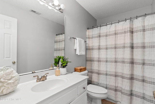 bathroom with toilet, vanity, a textured ceiling, and a shower with shower curtain