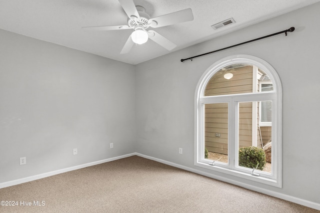 spare room featuring ceiling fan, a textured ceiling, and carpet floors