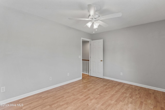 empty room with light wood-type flooring, a textured ceiling, and ceiling fan