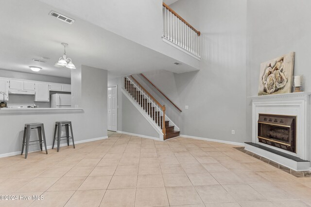 living room with light tile patterned floors and an inviting chandelier