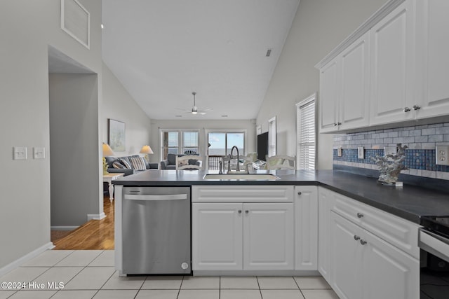 kitchen featuring dark countertops, visible vents, a peninsula, stainless steel dishwasher, and a sink