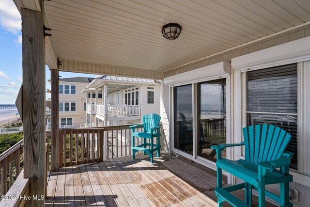 deck featuring a water view and a beach view