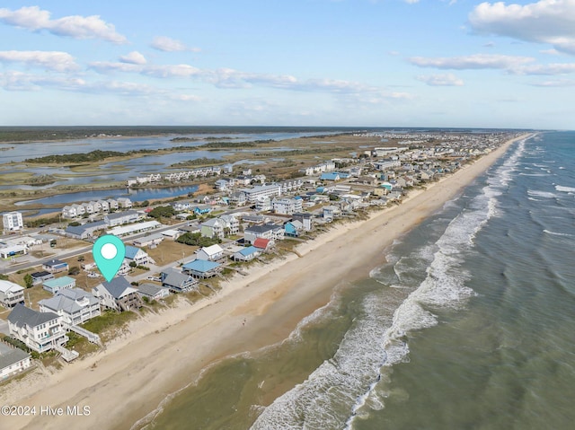 birds eye view of property with a water view and a beach view