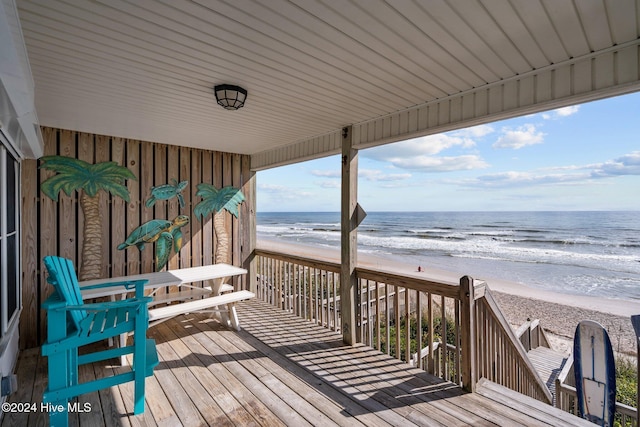 deck featuring a water view and a beach view