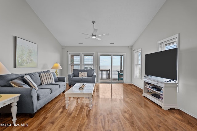 living area featuring visible vents, baseboards, wood finished floors, high vaulted ceiling, and a ceiling fan