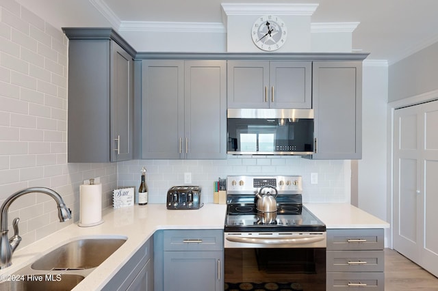 1796 New River Inlet Rd, North Topsail Beach, NC 28460 - kitchen with stainless steel appliances, gray cabinets, a sink, and ornamental molding
