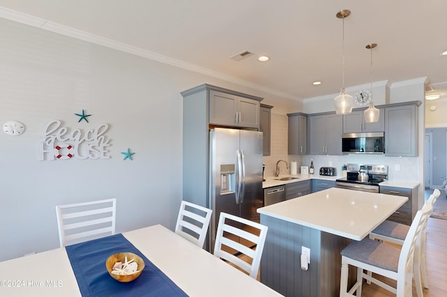 1796 New River Inlet Rd, North Topsail Beach, NC 28460 - kitchen featuring appliances with stainless steel finishes, gray cabinetry, a sink, a breakfast bar area, and tasteful backsplash