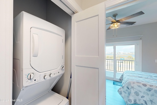 washroom with stacked washing maching and dryer, hardwood / wood-style flooring, and ceiling fan