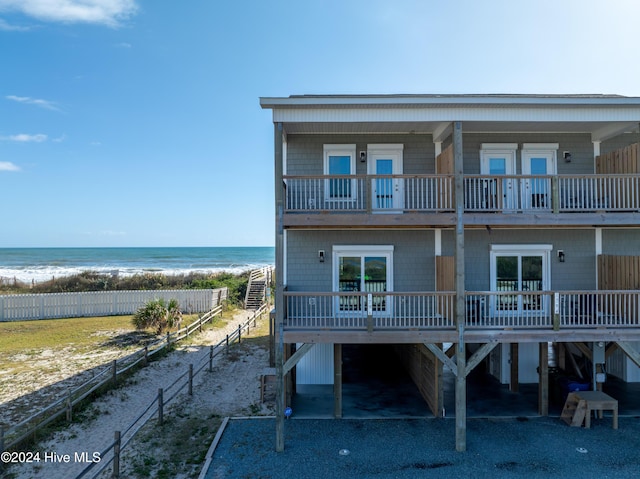 1796 New River Inlet Rd, North Topsail Beach, NC 28460 - view of front of house featuring a balcony, a carport, view of water and beach, and asphalt driveway