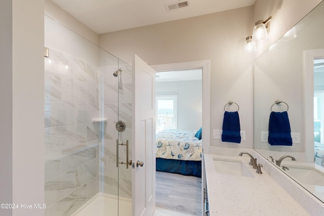 bathroom featuring hardwood / wood-style floors, an enclosed shower, and sink