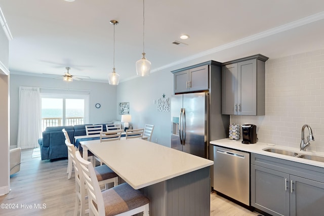 kitchen with stainless steel appliances, light hardwood / wood-style floors, sink, and tasteful backsplash