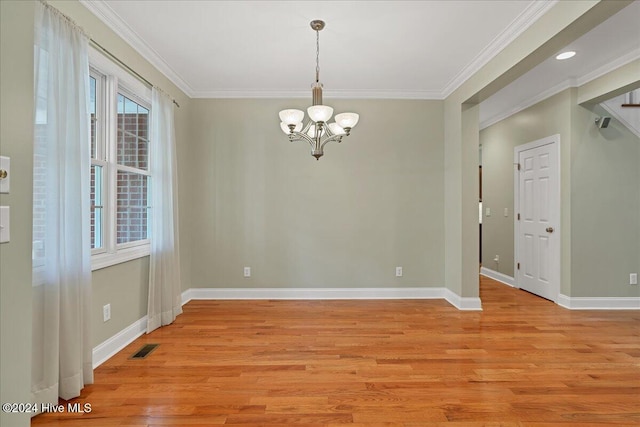 empty room with an inviting chandelier, light wood-type flooring, and crown molding