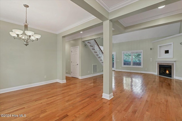 unfurnished living room with light wood-type flooring, a notable chandelier, ornamental molding, and beam ceiling