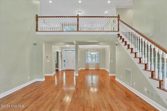 entrance foyer featuring a high ceiling, wood-type flooring, and a chandelier