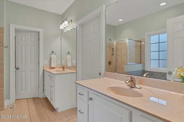 bathroom with walk in shower, vanity, and tile patterned floors