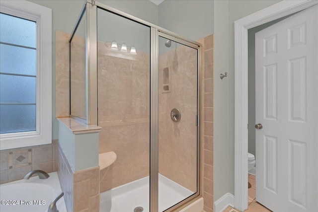 bathroom with tile patterned floors, toilet, and plus walk in shower