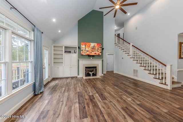 unfurnished living room with hardwood / wood-style floors, high vaulted ceiling, and ceiling fan