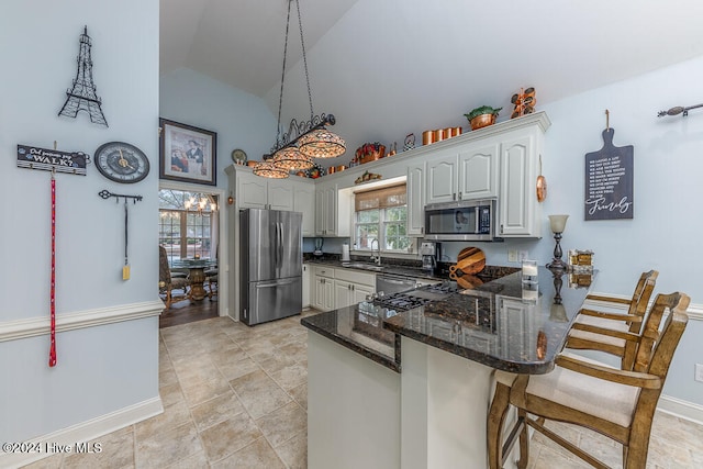 kitchen featuring sink, kitchen peninsula, decorative light fixtures, white cabinetry, and stainless steel appliances