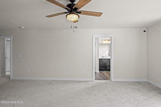 empty room featuring ceiling fan, carpet floors, and a textured ceiling