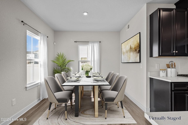 dining space with a healthy amount of sunlight and light hardwood / wood-style floors