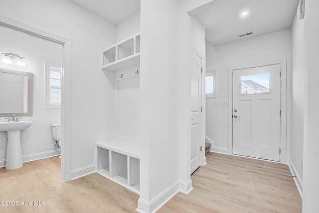 mudroom with sink and light hardwood / wood-style floors