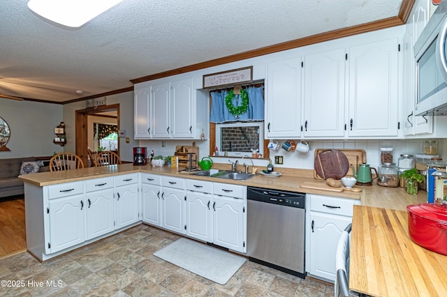 103 Shamrock Rd, Goldsboro, NC 27530 - kitchen with stainless steel appliances, a peninsula, crown molding, a textured ceiling, and a sink