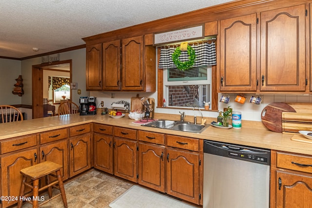 kitchen with a textured ceiling, ornamental molding, stainless steel dishwasher, and sink