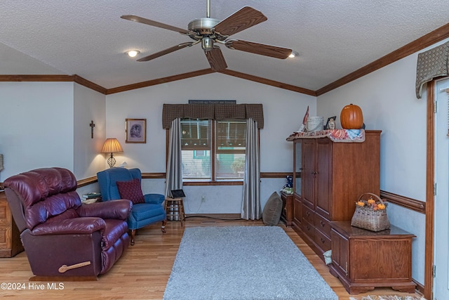 living room with light hardwood / wood-style floors, ceiling fan, a textured ceiling, and lofted ceiling