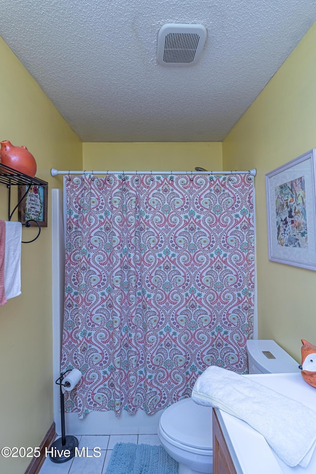 103 Shamrock Rd, Goldsboro, NC 27530 - bathroom with toilet, tile patterned floors, a textured ceiling, and shower / tub combo