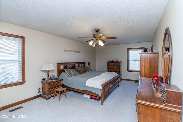 carpeted bedroom featuring a textured ceiling and ceiling fan