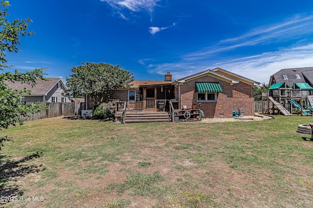 103 Shamrock Rd, Goldsboro, NC 27530 - back of property with brick siding, a playground, a wooden deck, and a chimney